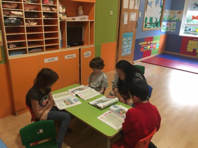 Profesora Lin Cao enseñando a niños en una mesa